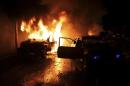Cars burn at the site of an explosion in the Shi'ite town of Hermel