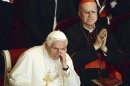Vatican State Secretary Cardinal Tarcisio Bertone observes Pope Benedict XVI at La Scala theater during a concert in Milan