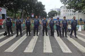 Bangladeshi police officials stand guard on a street …