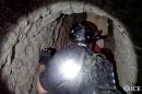 An Oct. 31, 2013, photo released by U.S. Immigration and Customs Enforcement shows agents in a tunnel designed to smuggle drugs from Tijuana, Mexico, to San Diego. The tunnel is equipped with electricity, ventilation and a rail system, U.S. authorities said. Authorities seized more than 8 tons of marijuana and 325 pounds of cocaine in connection with the discovery, ICE said. (AP Photo/U.S. Immigration and Customs Enforcement, Paul Caffrey)