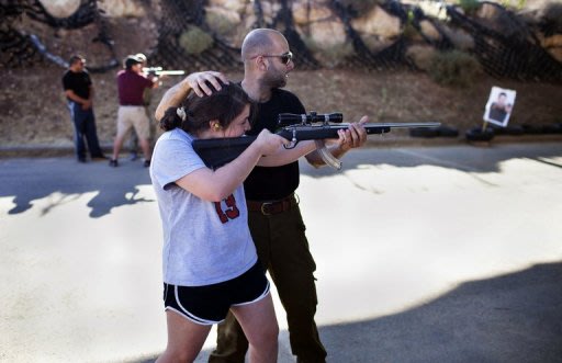 Un instructeur israélien apprend à une touriste américaine comment tirer, dans un centre de Cisjordanie, le 2 juillet 2012