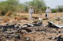 Forensics gather evidence at the crash site of the Air Algerie flight AH5017 in Mali's Gossi region on July 29, 2014