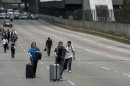 Passengers walk to Mexico City's international airport as teachers block access highways to protest education reform