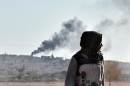 Black smoke rises during ongoing fighting in the Syrian town Kobane by the Kurds, as seen from the Turkish-Syrian border, in the southeastern town of Suruc, on October 8, 2014