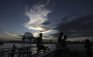 Thai boys are silhouetted as they sit on a jetty on the bank of the swollen Chao Phraya River in Bangkok, Thailand, Saturday, Oct. 29, 2011. Defenses shielding the center of Thailand's capital from the worst floods in nearly 60 years mostly held at critical peak tides Saturday, but areas along the city's outskirts remained submerged along with much of the countryside. (AP Photo/Altaf Qadri)
