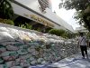 A man strolls past Bangkok Bank headquarters with a sandbag wall to prevent from flooding Saturday, Oct. 15, 2011 in Bangkok, Thailand. Fear and confusion gripped Bangkok as residents grappled with mixed messages over whether Thailand's worst floods in decades would overwhelm the intricate defenses of the low-lying metropolis of 9 million people. (AP Photo/Apichart Weerawong)