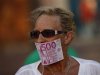 A woman covers her mouth with a fake Euro note during a protest against Spain's bailout in Malaga