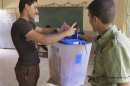 A youth casts his vote into a ballot box during the Iraq's provincial elections at a polling station in Ramadi