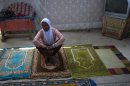 In this Sept. 28, 2012 photo, Darlene Derosier, 43, a Muslim, sits on a prayer rug at the Al-Fattah Mosque in Gressier, Haiti. Islam has won a growing number of followers in this impoverished country, especially after the catastrophic earthquake in 2010 that killed hundreds of thousands and left millions more homeless. Derosier said what's helped pull her through all the grief has been her faith, but not of the Catholic, Protestant or even Voodoo that's dominated this island country. Instead, she's converted to a new religion here, Islam, and built a small neighborhood mosque out of cinderblocks and plywood, where some 60 Muslims pray daily. (AP Photo/Dieu Nalio Chery)