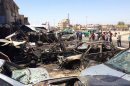Residents gather at the site of a massive car bomb attack in Baghdad that killed at least 55 people on July 29.