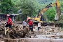 Rescuers and local residents search for the body of a child amid the damage caused by a landslide ensuing the passage of Tropical Storm Earl in the community of Xaltepec, Puebla state, eastern Mexico on August 8, 2016