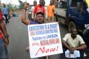 Nigerian students and workers carrying placards sit on Lagos-Ikorodu highway during a rally in Lagos, on August 13, 2013