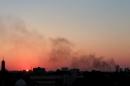 Black smoke billows in the sky above areas where clashes are taking place between pro-government forces, who are backed by the locals, and the Shura Council of Libyan Revolutionaries, an alliance of former anti-Gaddafi rebels