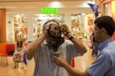Israeli Aviv Levy tries on a gas mask at a distribution center in a shopping mall in Mevaseret Zion near Jerusalem, Wednesday, July 25, 2012. Israel's foreign minister warned on Wednesday his country will act immediately if it discovers Islamic militants are raiding Syria's chemical or biological weapons stocks, while Israelis rushed to stock up on gas masks as the bellicose rhetoric swells. (AP Photo/Sebastian Scheiner)