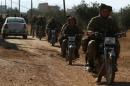 Rebel fighters drive their motorcycles, western Aleppo city