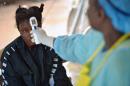 A girl suspected of being infected with the Ebola virus has her temperature checked at the government hospital in Kenema, Sierra Leone on August 16, 2014