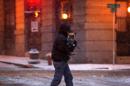 A man holds his dog as he rushes across the street in downtown St. Paul, Minn., during the first snowstorm of the season on Monday, Nov. 10, 2014. Though the snow will largely stop in Minnesota by Tuesday afternoon, said Joe Calderone, senior forecaster at the National Weather Service office in Chanhassen, Minnesota, the state won't be 