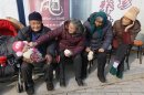 An elderly couple feed their great-grandson with a piece of cake as they sit under the sun in winter in Jiaxing, Zhejiang province