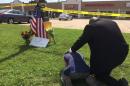 A man prays over a sobbing citizen next to a U.S. flag at the site of a shooting attack on a Naval recruiting center in Chattanooga