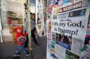 A woman and her son walk past a newspaper stand displaying a local newspaper with a headline for the victory of U.S. Republican president-elect Donald Trump, in Ciudad Juarez