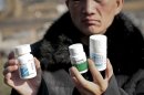 In this Nov. 20, 2012 photo, 28-year-old HIV patient Wang Pinghe shows bottles of medicine pills he has been taking during an interview in Beijing, China. Wang has a tumor in his liver and he wants it surgically removed before it becomes life-threatening, but it will be hard to find a hospital that will do the operation because he has AIDS. In China, hospitals routinely reject people with HIV for surgery out of fear of exposure to the virus or harm to their reputations (AP Photo/Gillian Wong)