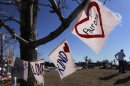 Signs drawn on fabric are seen hanging from a tree at a memorial for victims behind the theater where a gunman opened fire on moviegoers in Aurora