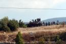 A picture released by the Syrian Arab News Agency on August 8, 2013 shows Syrian army soldiers stand next to a tank in the Latakia province