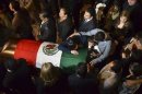 Family members, friends and colleagues of Mexican congressman Esquivel Lucatero surround his coffin in Morelia