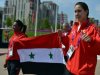 Syrian athletes Ghufran Almohamad and Bayan Jumah (right) carry their national flag