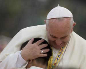 Pope Francis hugs a child during his meeting with the …