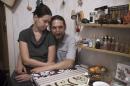 In this photo taken on Saturday, Dec. 27, 2014, Dmitry Dervenyov, 50, right, and his wife Svetlana Suvorova, 32, sit in their flat in St.Petersburg, Russia. Dmitry his wife Svetlana have finally managed to refinance their 15-year dollar mortgage loan with DeltaCredit bank into rubles on Friday, Dec. 23, 2014. The refinancing increased their monthly payments in rubles almost twice compared to the beginning of the year but it still made them feel safer.(AP Photo/Dmitry Lovetsky)