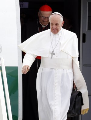Pope Francis, holding his bag and followed by Vatican …