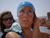 U.S. swimmer Diana Nyad adjusts her swimming cap as a woman applies a protective ointment to her skin as she prepares to jump into the water and start her swim to Florida from Havana, Saturday, Aug. 18, 2012.  Endurance athlete Nyad launched another bid Saturday to set an open-water record by swimming from Havana to the Florida Keys without a protective shark cage. (AP Photo/Ramon Espinosa)