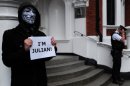 A protester wearing a Guy Fawkes mask holds a poster reading "I'm Julian" outside the Ecuadorian embassy in London