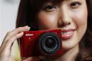File photo shows model poses with Nikon Corp's new Nikon 1 J1 camera at its unveiling ceremony in Tokyo