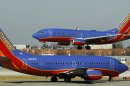 In this Feb. 9, 2012 file photo, a Southwest Airlines Boeing 737 waits to take off at Chicago's Midway Airport as another lands. A spokesman for Southwest Airlines says all departing flights have been grounded due to a system-wide computer problem, Saturday, June 22, 2013. (AP Photo/Charles Rex Arbogast)