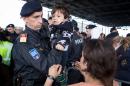 An Austrian policeman helps a child as refugees crowd at a border crossing in Nickelsdorf at the Austrian-Hungarian border on September 20, 2015