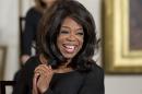 FILE - In this Nov. 20, 2013, file photo, Oprah Winfrey smiles before being awarded the Presidential Medal of Freedom by President Barack Obama in the East Room of the White House in Washington. If Donald Sterling is compelled to sell the Los Angeles Clippers, the list of potential buyers will have more stars than the team's roster. Winfrey leads the list of wealthy luminaries who announced their interest in purchasing the club shortly after NBA Commissioner Adam Silver banned Sterling from the league for life. (AP Photo/ Evan Vucci, File)