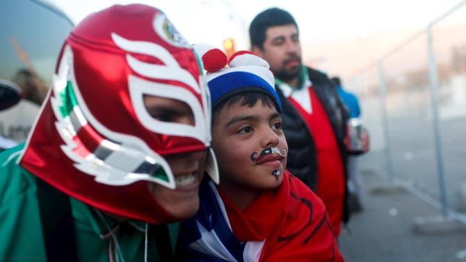 Fans of Mexico and Chile cheer before their Copa America soccer match at the National Stadium in Santiago