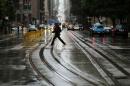 A pedestrian crosses the idle California Street cable car line in San Francisco