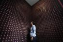 A woman stands next to more than 2,000 chocolate samples adhered to the walls inside "Mucho", a chocolate museum, in Mexico City