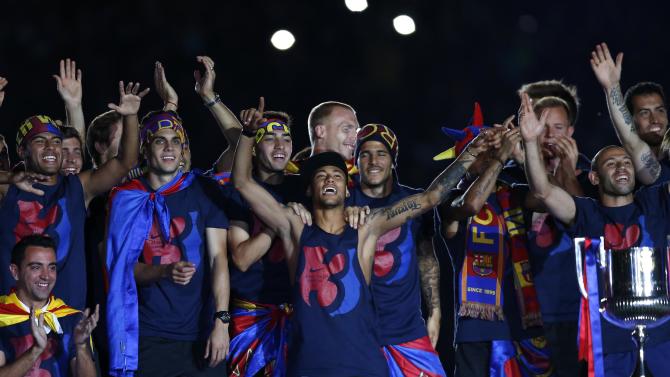 Barcelona&#39;s Neymar, center, celebrates with team mates at the Camp Nou stadium in Barcelona, Spain Sunday June 7, 2015 after winning the Champions League final soccer match Saturday by beating Juventus Turin 3-1. Barcelona won the triple this season winning the Spanish League title, the Copa del Rey and the Champions League. (AP Photo/Manu Fernandez)