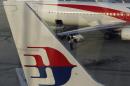 An airport worker walks between Malaysia Airlines planes at Kuala Lumpur International Airport