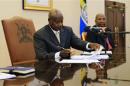 Uganda President Yoweri Museveni signs an anti-homosexual bill into law at the state house in Entebbe