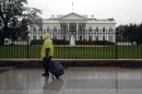 In this Monday, Oct. 29, 2012, photo, a lone man wearing a rain pouch walks past the White House in Washington, Monday, Oct. 29,2012, during the approach of Hurricane Sandy. Whoever wins the U.S. presidential election will likely struggle to manage the biggest economic threats he'll face. That's the cautionary message that emerges from the latest Associated Press Economy Survey. (AP Photo/Jacquelyn Martin)