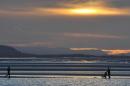 People walk and jog around the edge of the Marine Lake at West Kirby, on March 3, 2014, as the sun sets