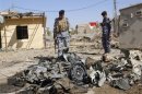 Policemen inspect the wreckage of a vehicle after a car bomb attack in Kirkuk