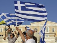 Man holds Greek flag before conservative New Democracy party rally at Syntagma square in Athens