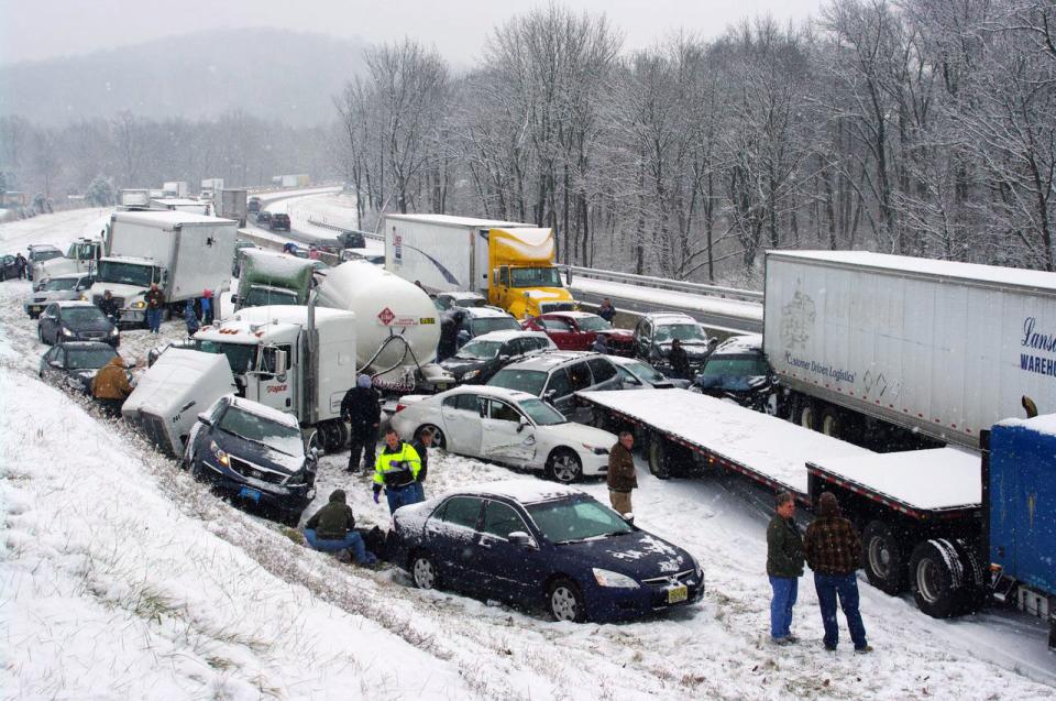 Vehicles are piled up at mile marker 286 on the Pennsylvania Turnpike, a mile outside Reading, Pa., on Thursday, Dec. 26, 2013. Portions of both the Pennsylvania Turnpike and Interstate 78 were shut down in snowy eastern Pennsylvania Thursday after chain-reaction pileups involved dozens of vehicles on slippery roads. (AP Photo/David C. Ronk)