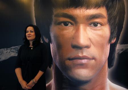 Shannon Lee, daughter the late Kung Fu legend Bruce Lee, poses in front of a portrait of her father at the Hong Kong Heritage Museum